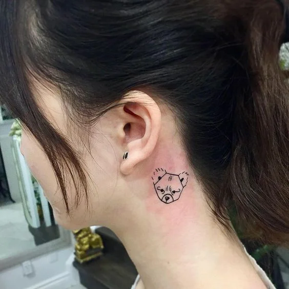 Small bear tattoo behind ear